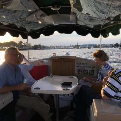 a group of people sitting at a table with an umbrella