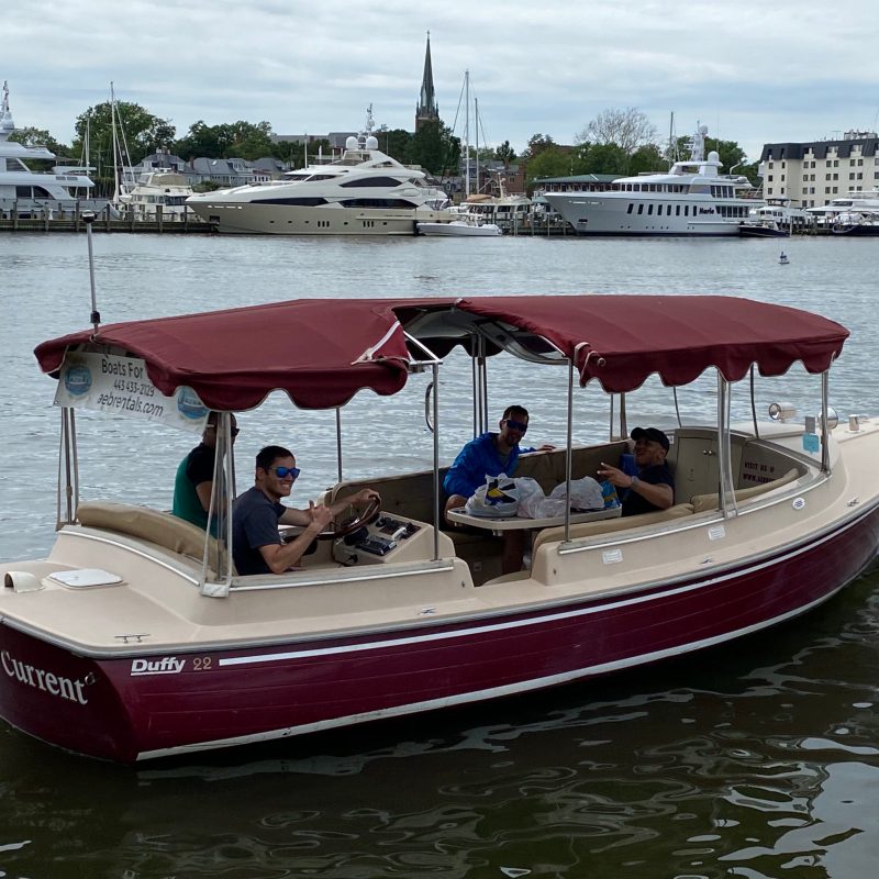 a red and white boat sitting next to a body of water