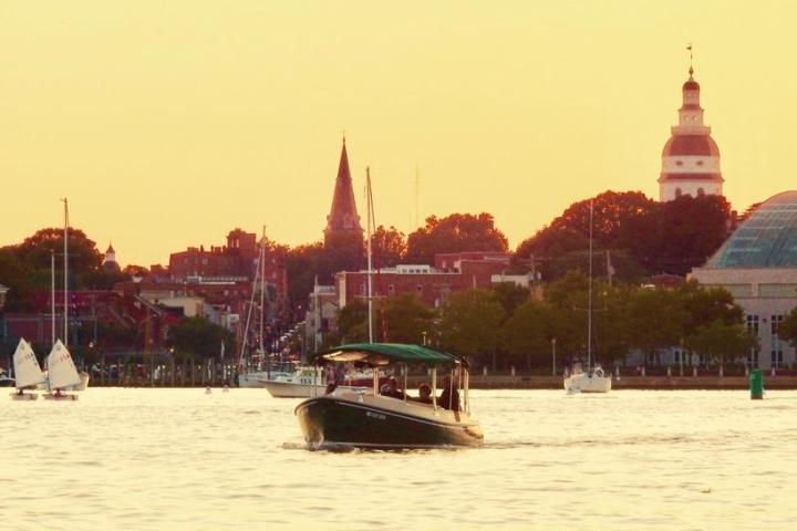 a small boat in a body of water with a city in the background
