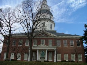 a large brick building with grass and trees