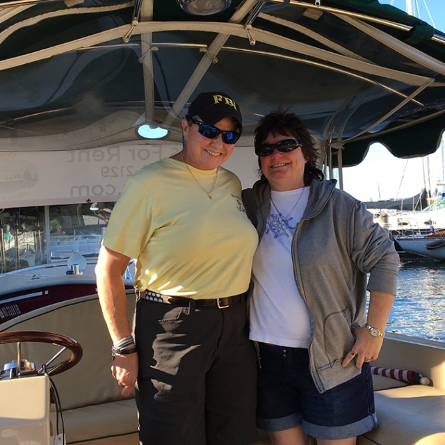 a man and a woman standing in front of a boat