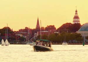 a small boat in a body of water with a city in the background