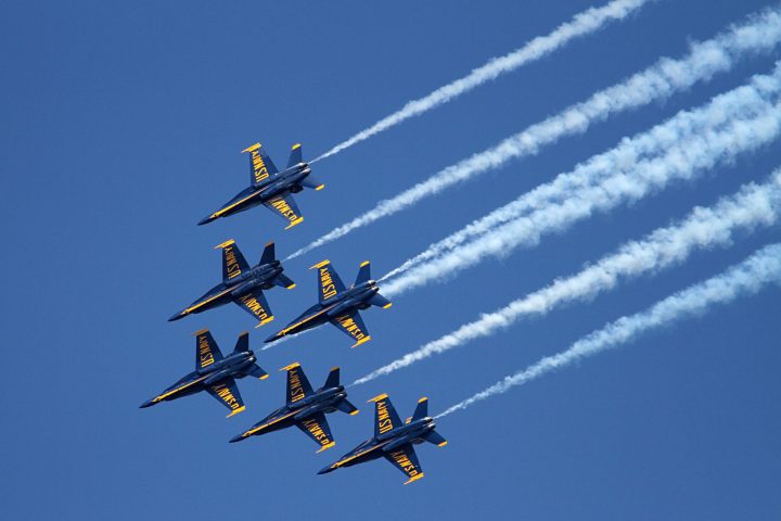 a group of fighter jets flying through a blue sky